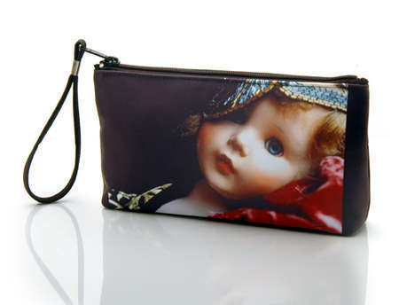 "Daniella the Doll"
Cosmetic/clutch bag with zipper closure, interior attached key fob   10" x 5.5" x 1.75"- at base 6.5" 